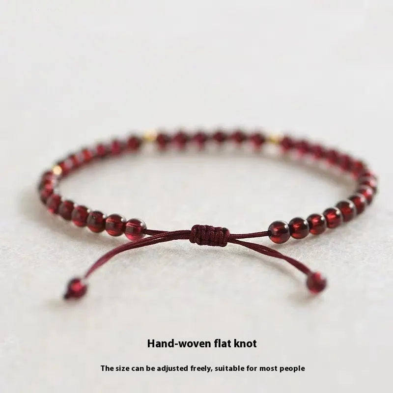 Hand-woven garnet red bracelet with flexible wire rope construction and Chinese national tide design
