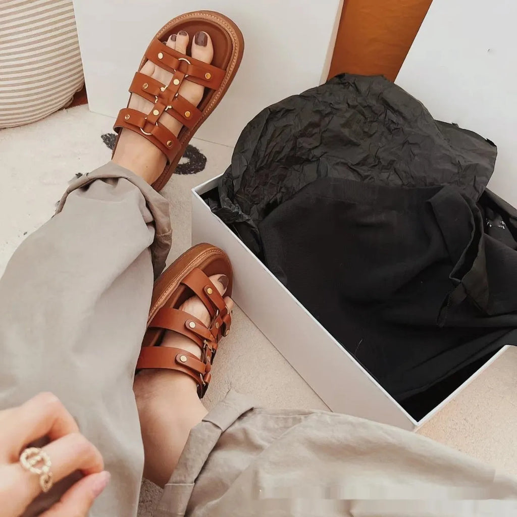 Women's white patent leather Roman sandal slippers with sheepskin lining, shown from the side.