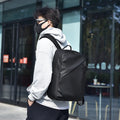 Large black waterproof PU leather backpack for men with prominent stitching, shown next to blue and grey colour options.