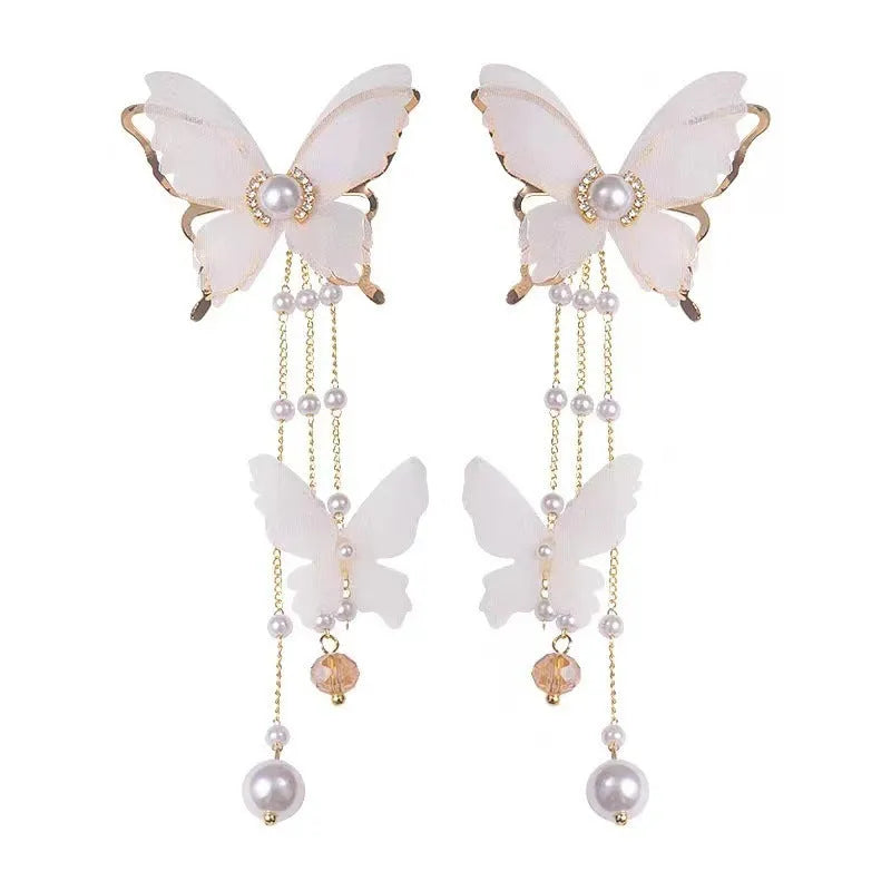 A pair of white butterfly-shaped earrings with tassel lace and pearl rhinestone details on electroplated copper alloy.