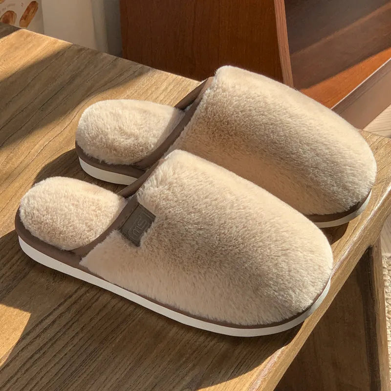 Blue PVC plush winter slippers with non-slip sole on a wooden floor.