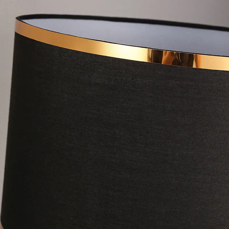 Iron table lamp with cloth shade in black, gold, or white colour on a wooden table
