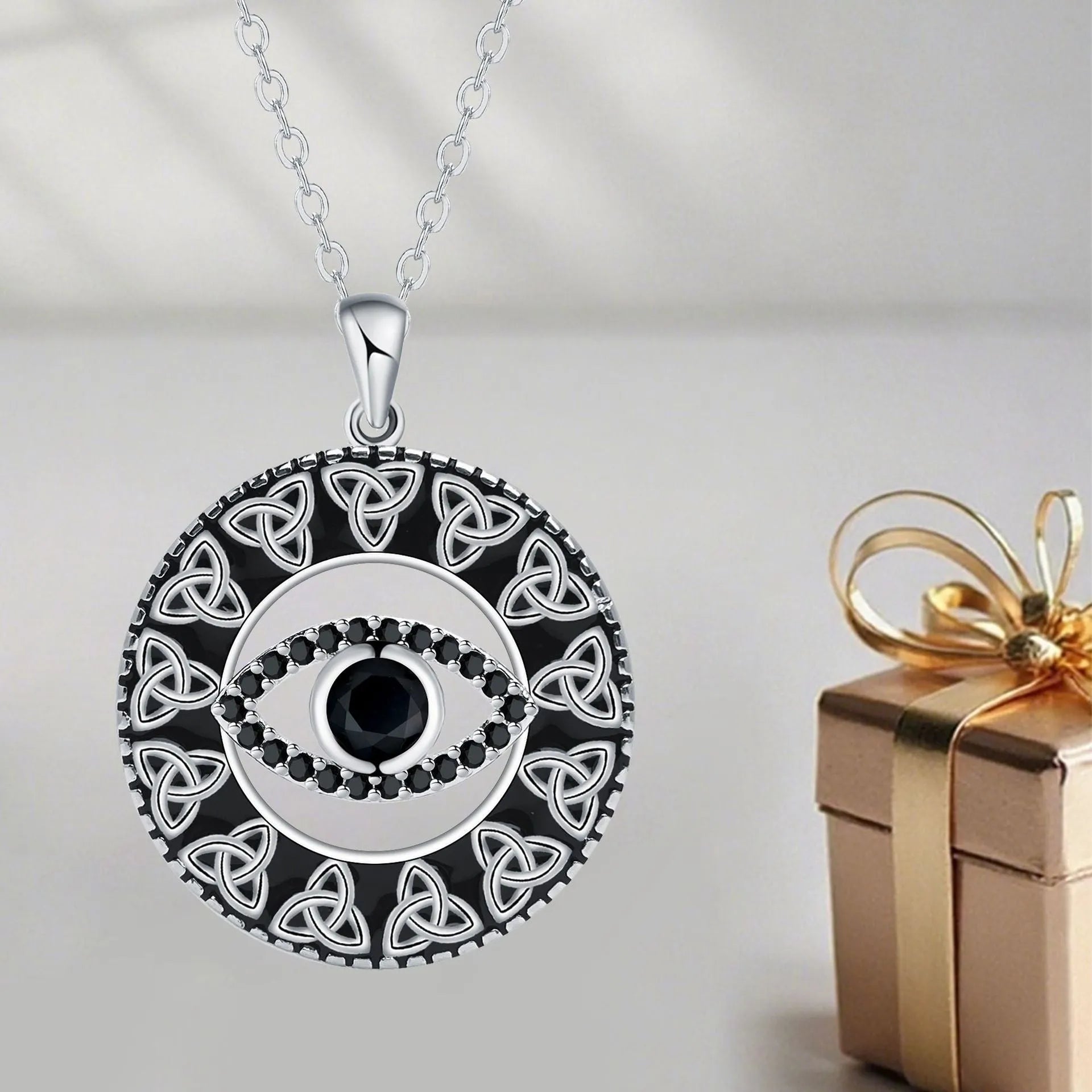 Close-up of a women's copper Devil's Eye pendant necklace on a cross chain, with a light luxury electroplated finish.