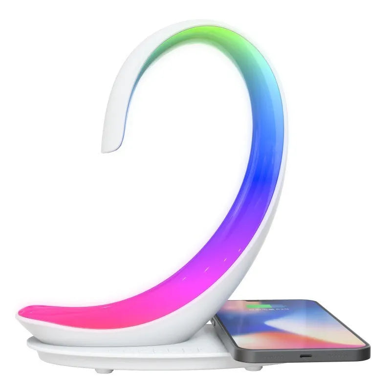 White swan sculpture desk lamp with integrated wireless phone charger and Bluetooth speaker emitting colourful light.