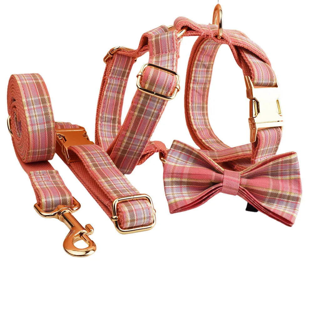 Plaid fabric dog collar, leash, bow, and vest four-piece accessory set on a white background.