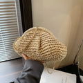 Women's beige shell-shaped paper straw bag with a metal chain strap.