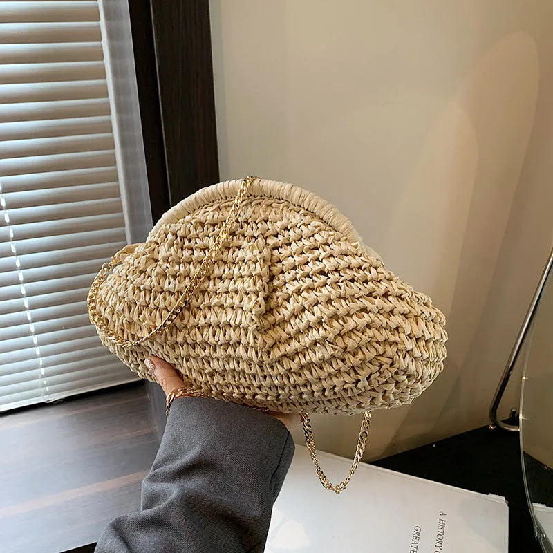 Women's beige shell-shaped paper straw bag with a metal chain strap.