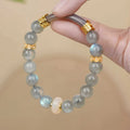 Grey moonstone bracelet with 8mm round beads on a wrist.