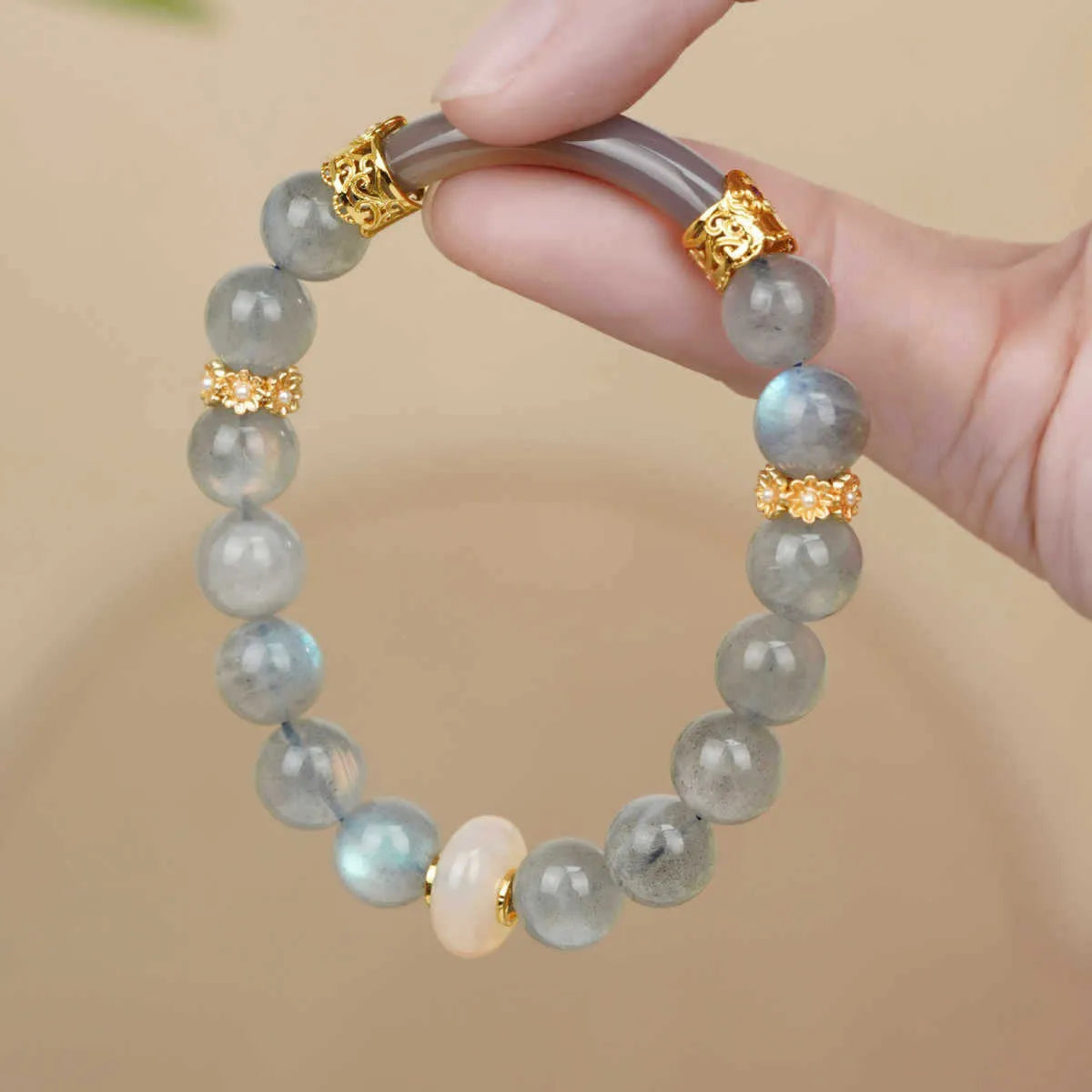Grey moonstone bracelet with 8mm round beads on a wrist.