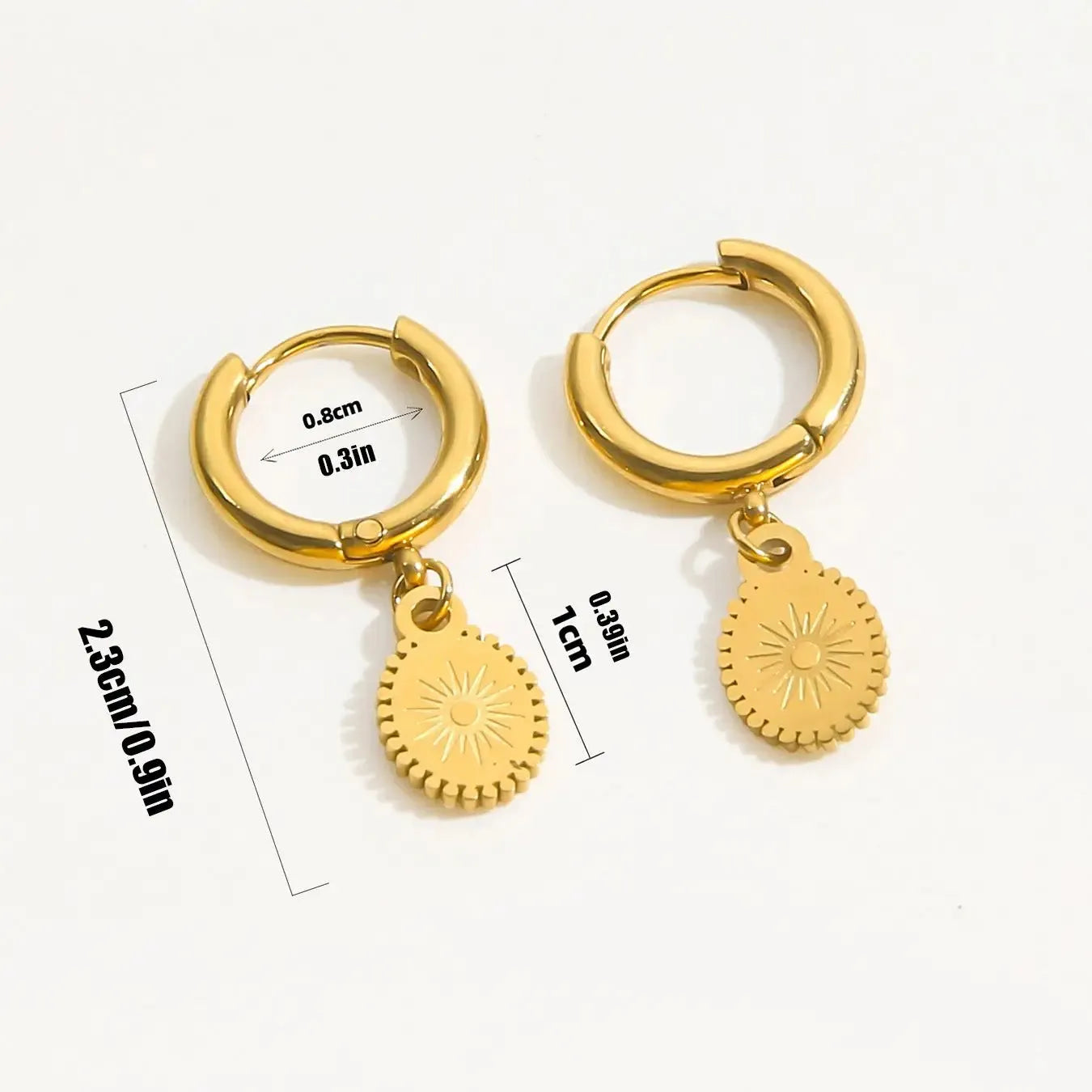 A pair of stainless steel geometric earrings featuring a central ellipse design on a woman's ear.