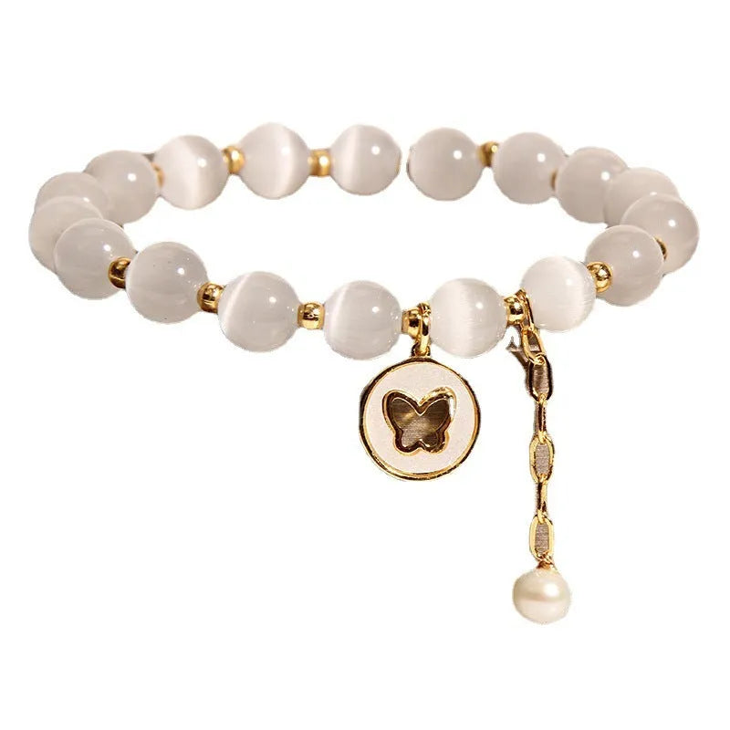 White geometric cat's eye crystal bracelet with a Korean-style design on a wrist.