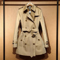 Khaki double-breasted women's trench coat with flight sleeves, shown on a hanger.
