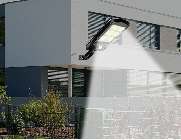 Black solar-powered outdoor motion sensor light mounted on a wall or fence post.