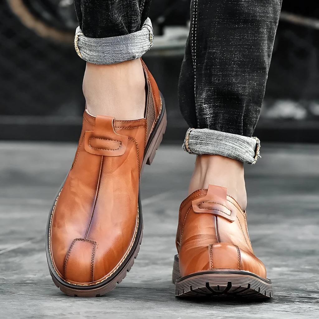 Men's black cowhide leather round toe loafers with rubber sole on a light background