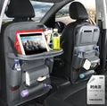 Black PU leather car seat back storage bag with multiple pockets hanging from a car headrest.