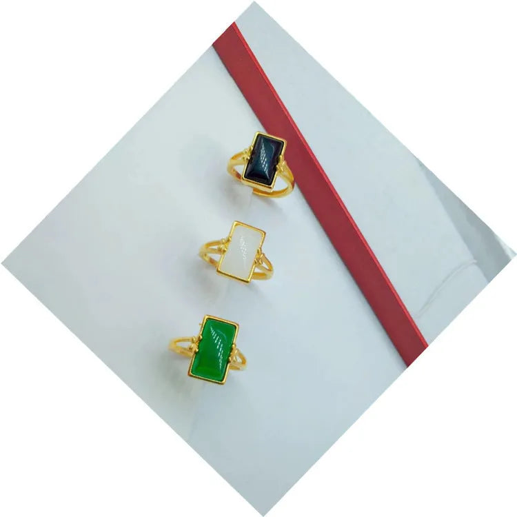 Adjustable gold plated brass ring with a national style design and a coloured inlaid gemstone.