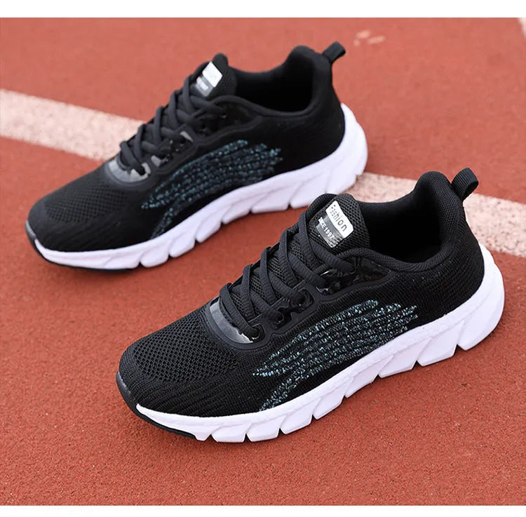 Low-top black and white running sneakers with cross-strap detail and a round toe on a flat MD sole.