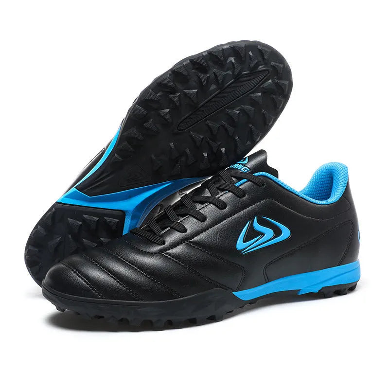 Low-top turf soccer shoes in black and white broken nails colour with synthetic leather upper