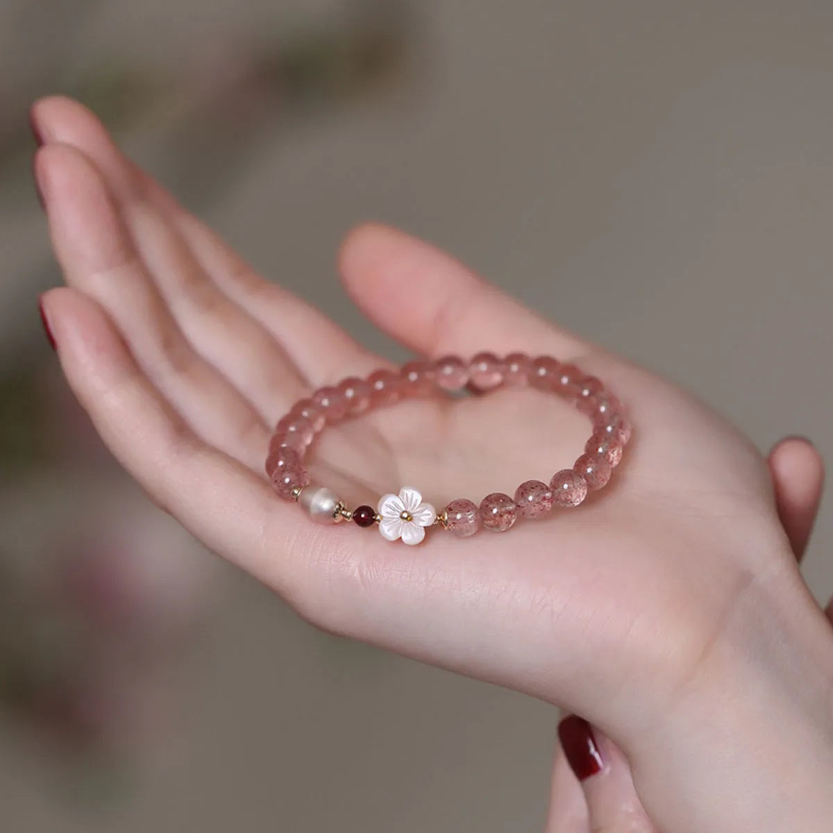 Strawberry quartz crystal bracelet with floral peach blossom design and silver-tone metal fittings