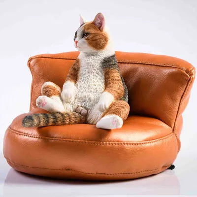 Lazy cat and sofa miniature car dashboard ornament made from resin, approximately 7.5cm high.
