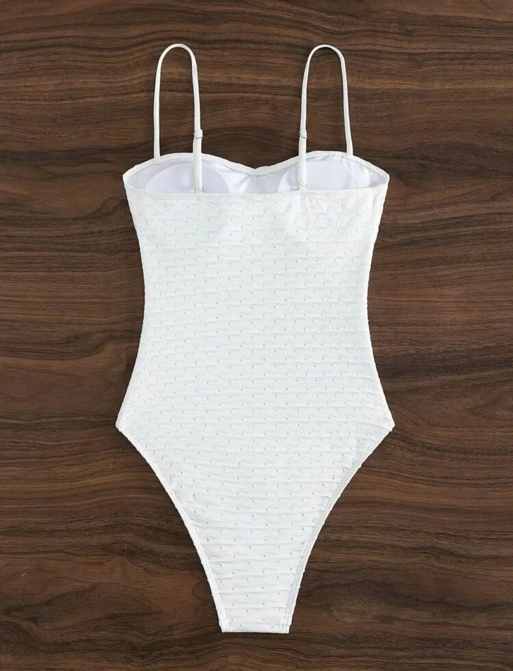 White one-piece swimsuit for women on a hanger, showing briefs style and sling detail.