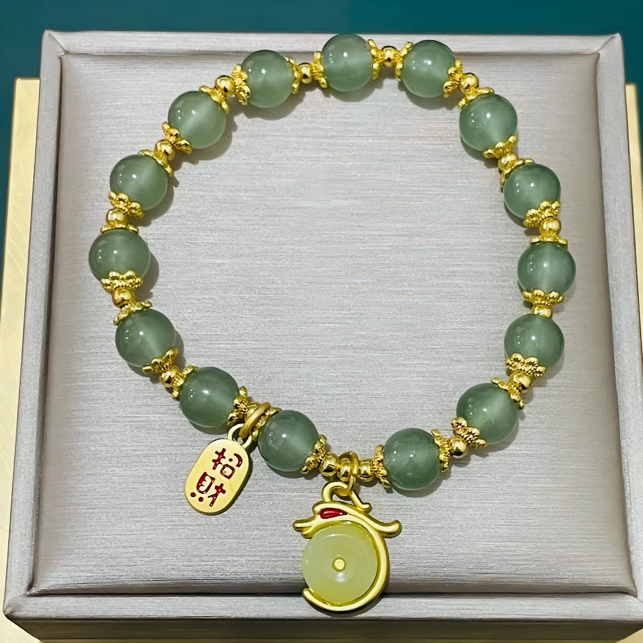 Handmade bracelet with glass beads, a rabbit charm, and a silver-coloured peace buckle on a white background.