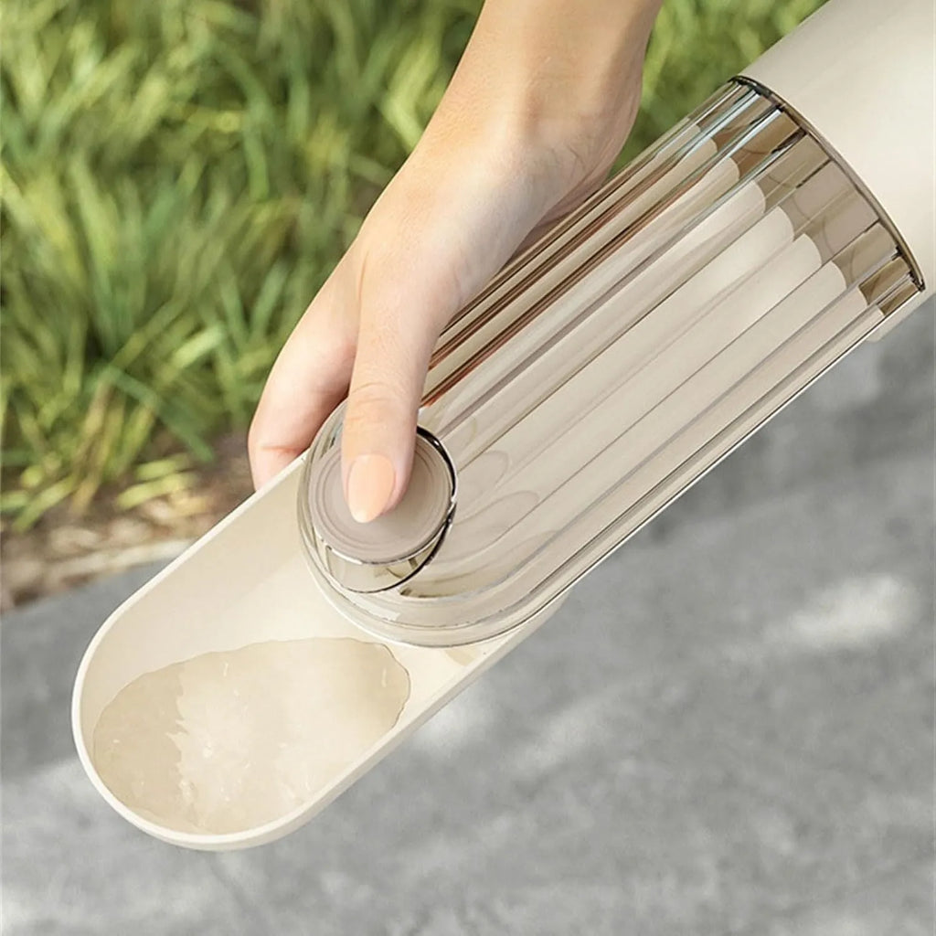 Beige dog water bottle with foldable silicone tray and integrated food dispenser base.