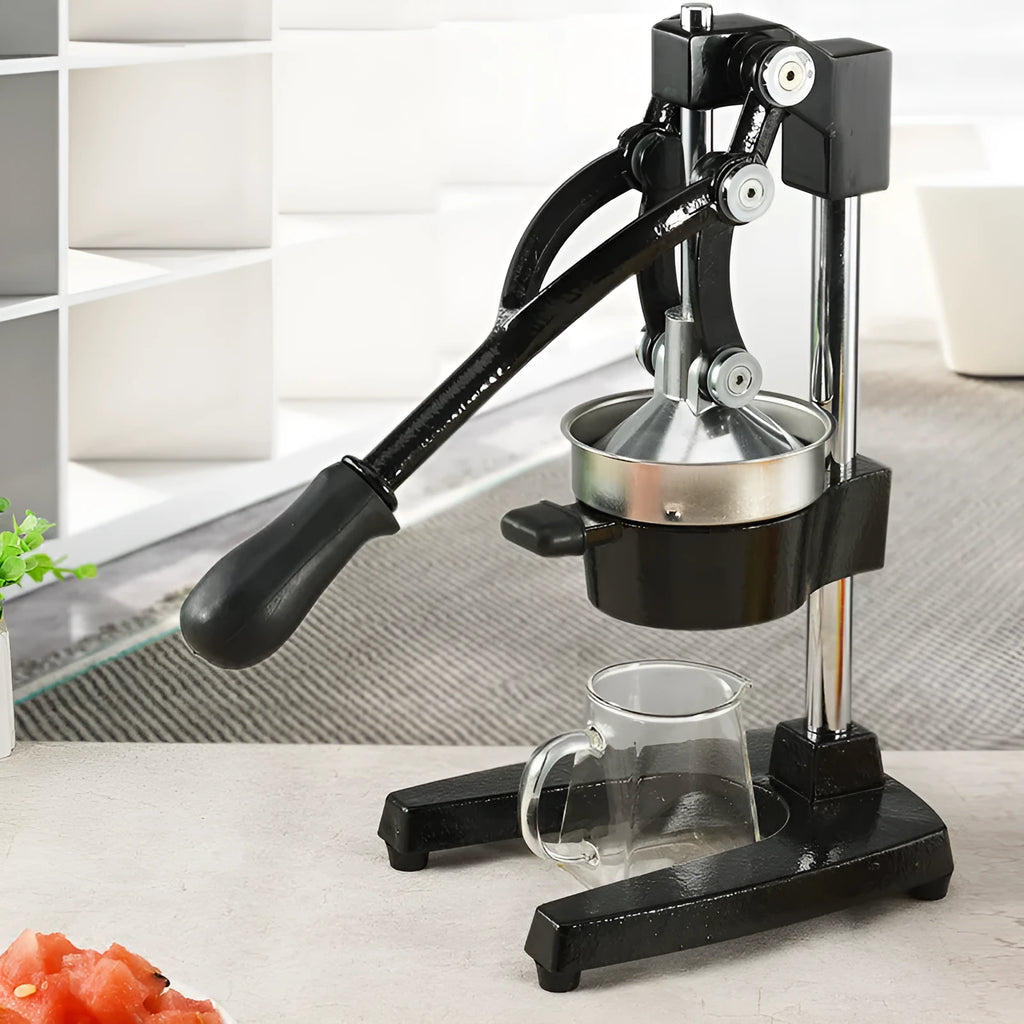 Black and white manual cast iron juicer with stainless steel funnel, 40 cm tall on kitchen counter.