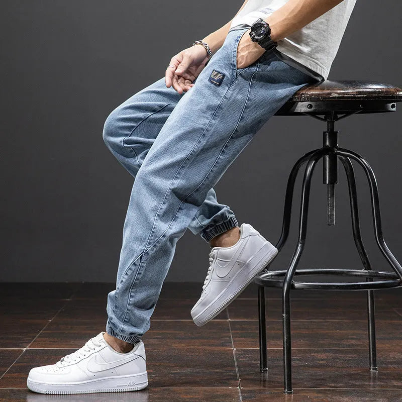 Men's loose fit straight leg cargo jeans in blue on a neutral background.