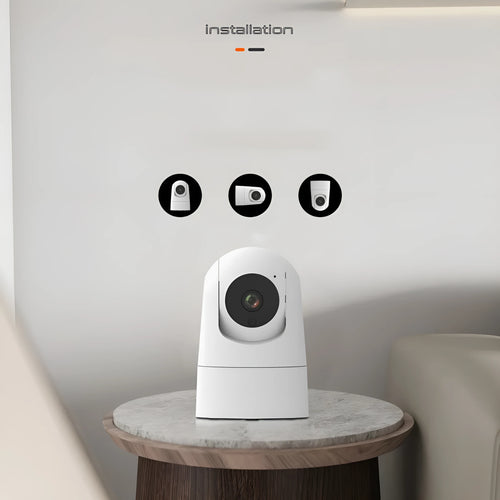White indoor security camera with shake head function on a desk, showing UK plug.