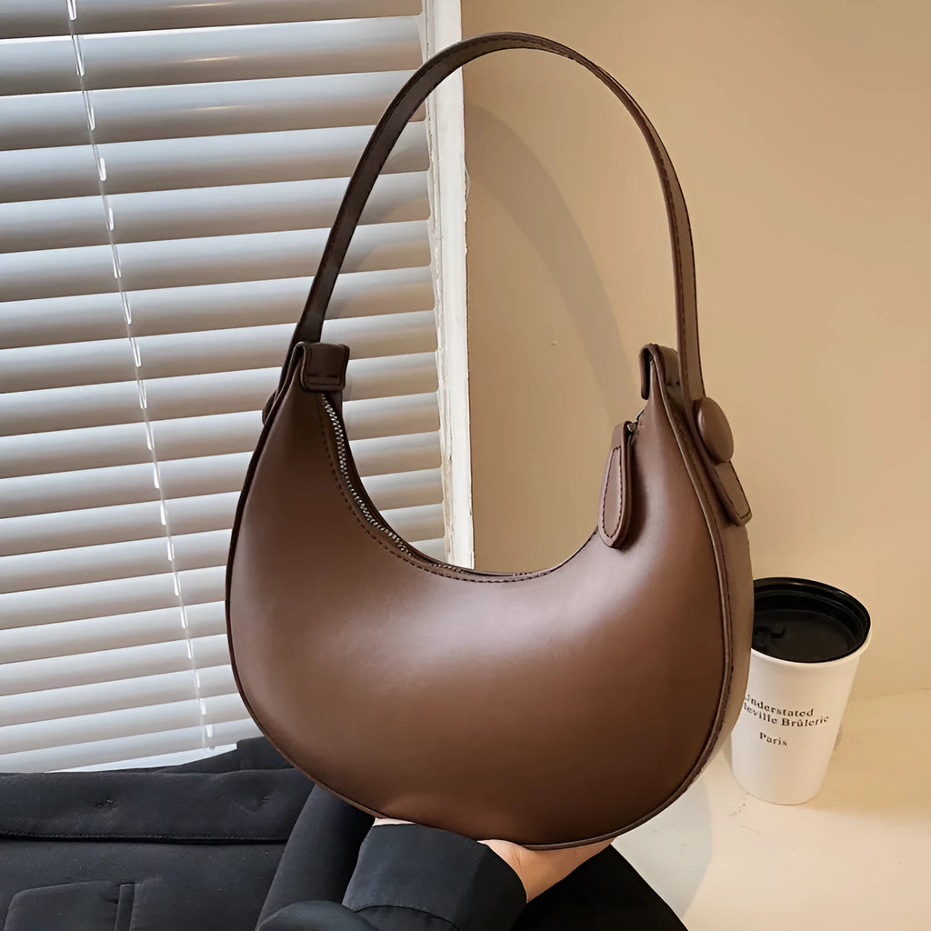 Women's retro dumpling-shaped shoulder bag in PU, shown in one of four colours, featuring an outer pocket and internal zipper compartment.