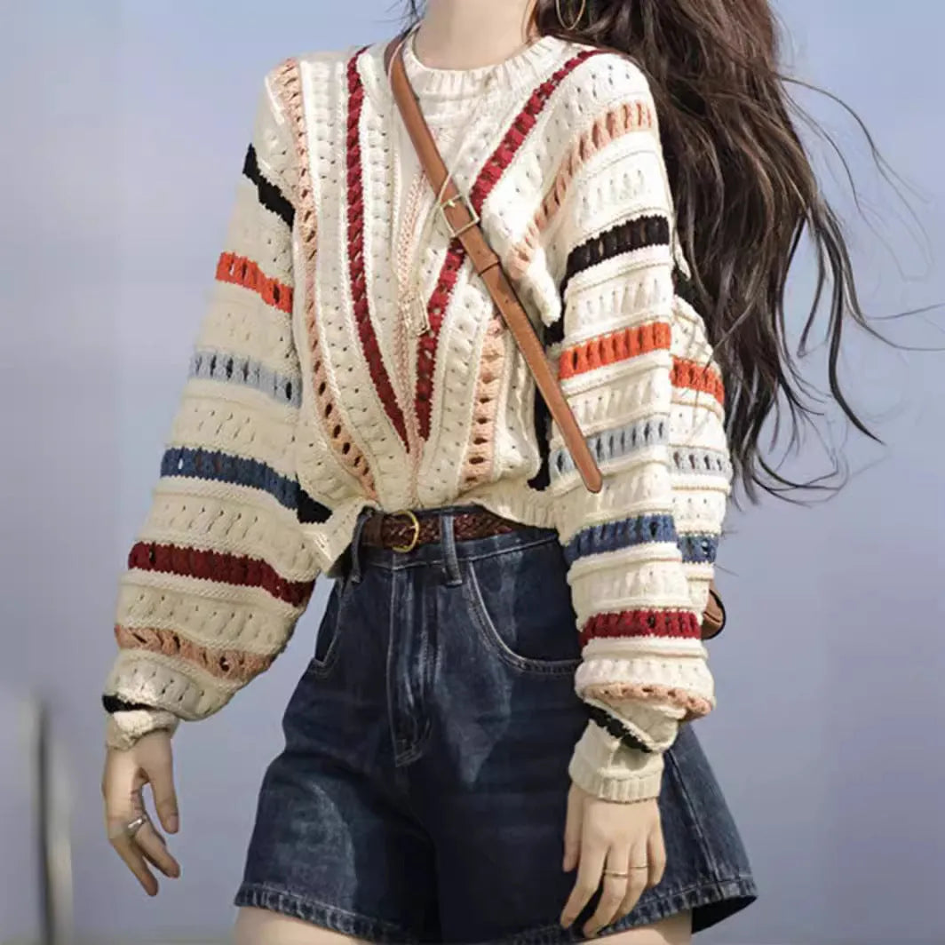 Colourful rainbow striped loose fit pullover sweater with batwing sleeves on a neutral background.