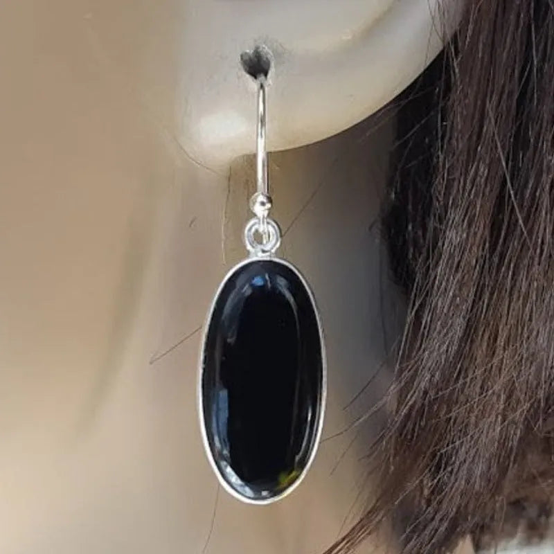 Black oval geometric earrings with Chinese style design on an electroplated alloy construction.