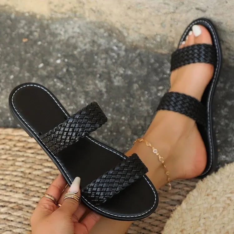Plus size women's woven synthetic leather beach slipper in gold colour on a sandy background.