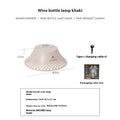 Beige and grey portable camping lantern with a wine bottle shaped lampshade and USB-C charging port.
