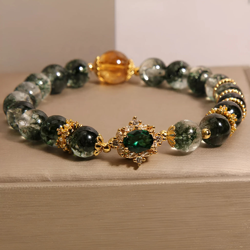 Women's green phantom quartz crystal bracelet with gold rutile needles, ruby quartz bead, pearls, and rhinestone details.