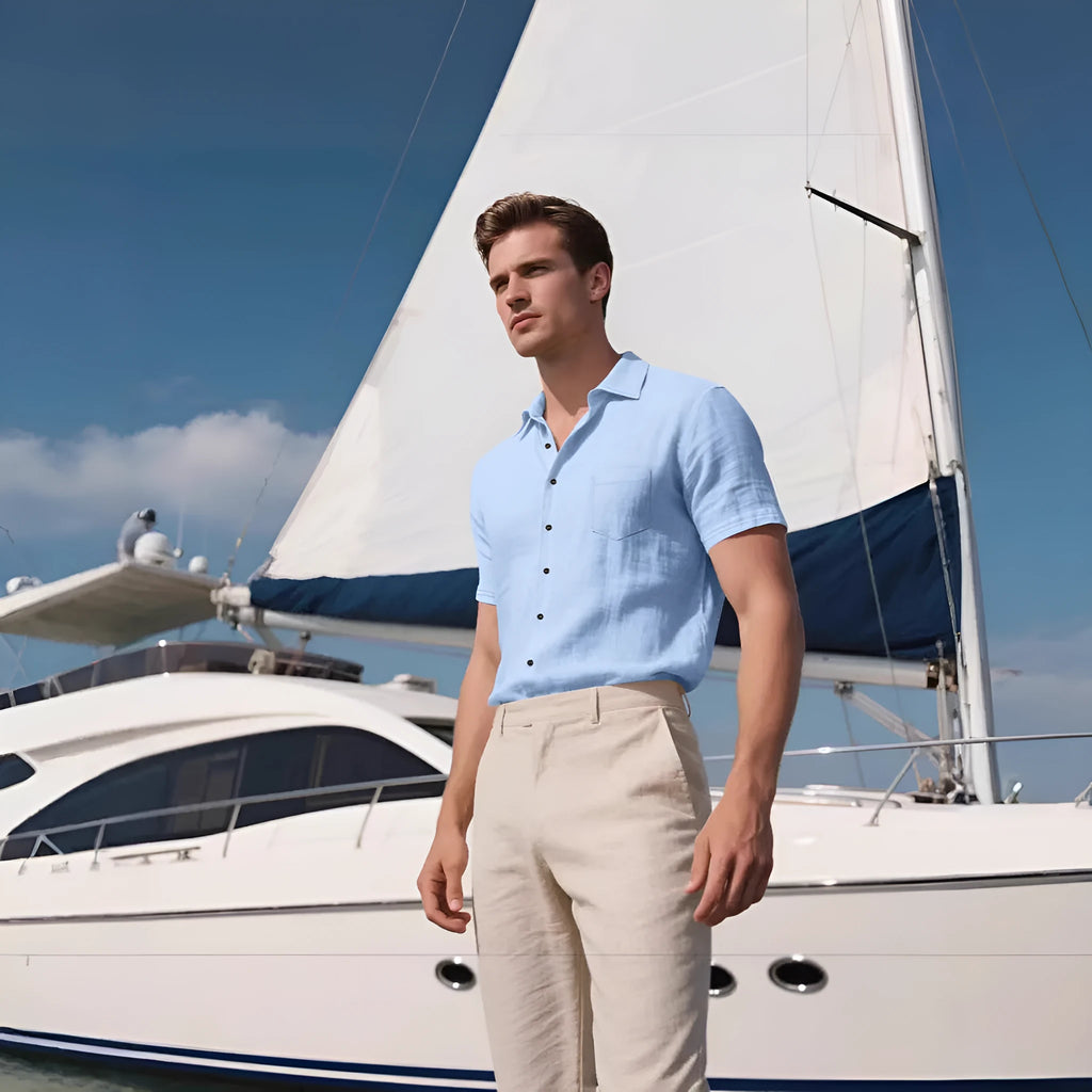 Man wearing a loose-fit, light blue, short-sleeved linen shirt in a cardigan style.