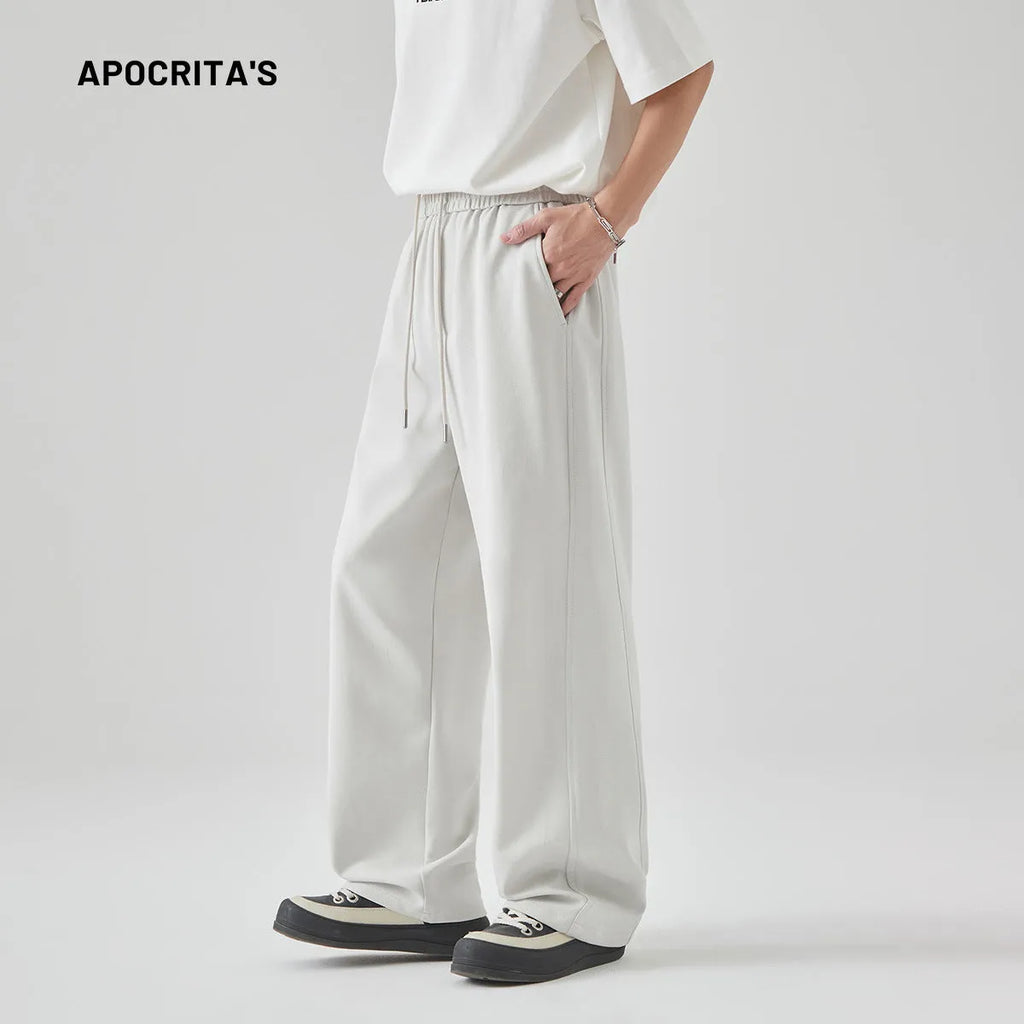 Men's grey high-waisted casual trousers with a lace-up front detail on a plain background.