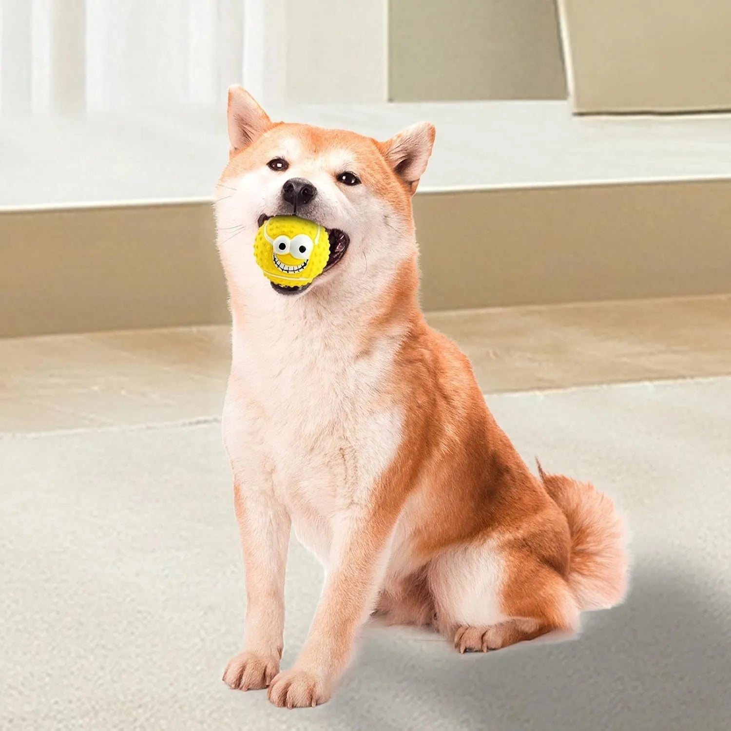 Green, orange, and yellow squeaky latex dog balls with smiley faces for pet play.