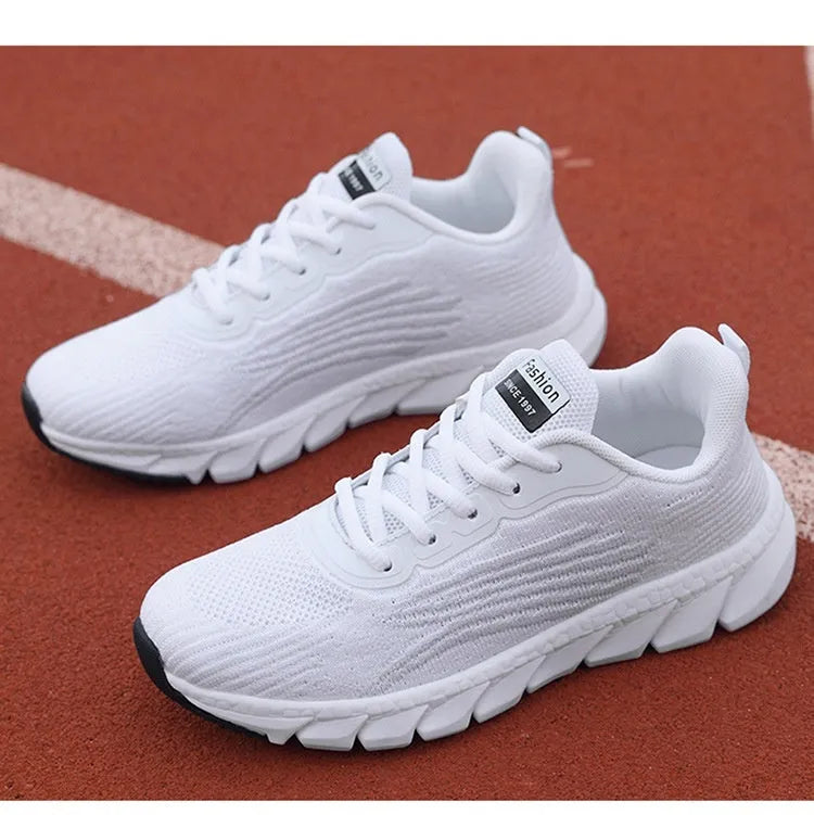 Low-top black and white running sneakers with cross-strap detail and a round toe on a flat MD sole.