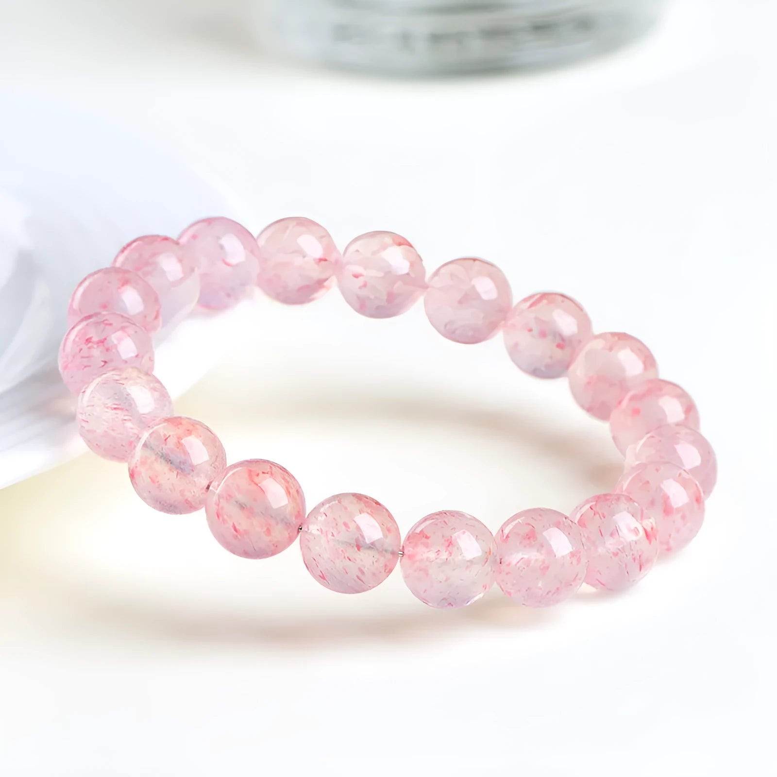 Strawberry quartz crystal bracelet with 10-10.8mm round beads in natural white water colour