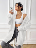 Women's dark green double pocket cardigan sweater with a V-neck and long sleeves laid flat.