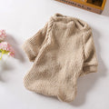 Brown knitted pullover sweater on a small dog, showing casual cloth design.
