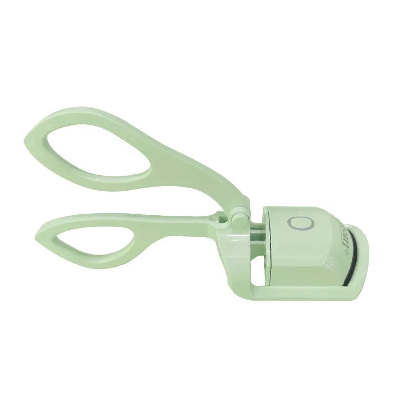 White USB rechargeable heated eyelash curler with dual temperature lights, shown next to its charging cable.
