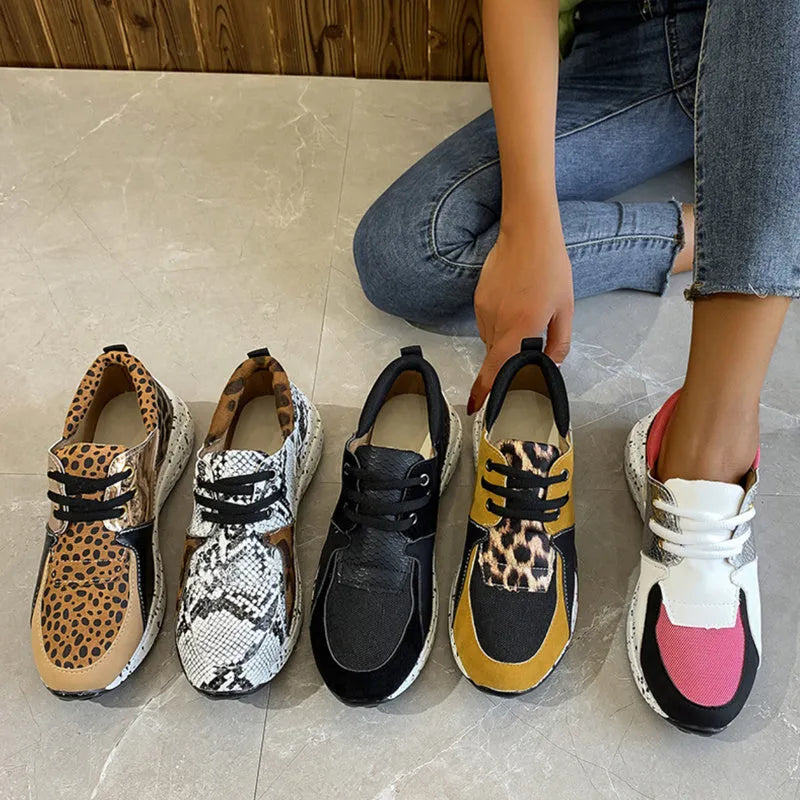 Women's black suede casual sneakers with a wedge heel and round toe on a plain background.