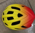 Orange ZH-002 adult cycling helmet showing ventilation holes and polycarbonate shell.