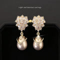 Women's drop-shaped earring with a white pearl and purple zircon stones on an 18K gold-plated setting.