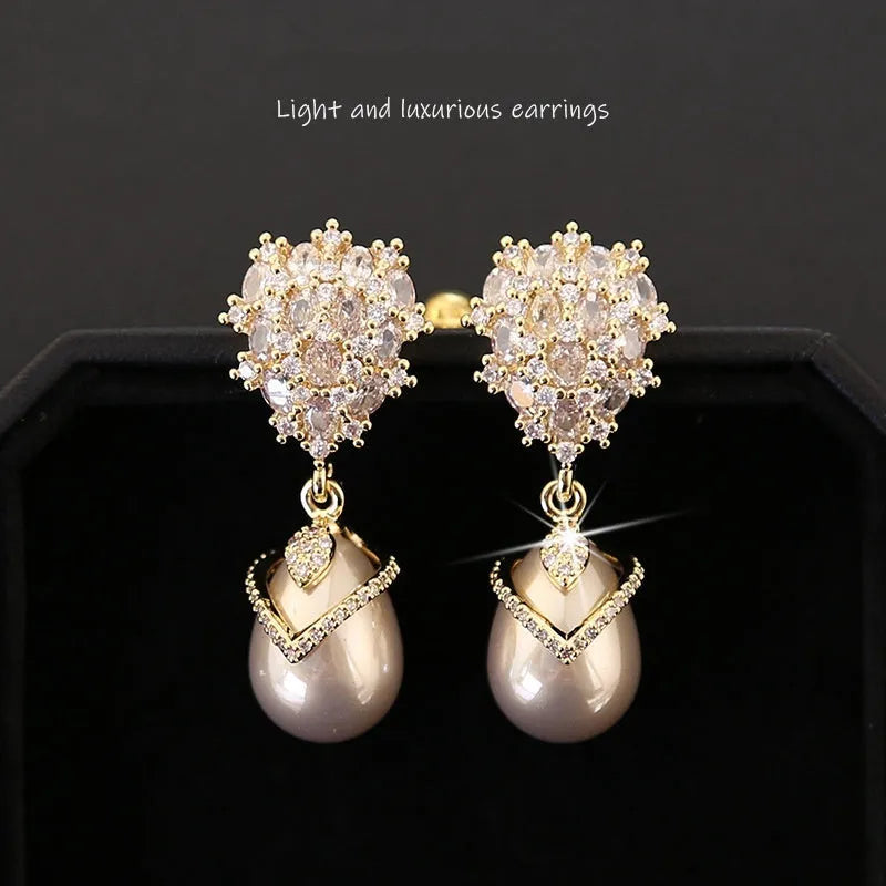 Women's drop-shaped earring with a white pearl and purple zircon stones on an 18K gold-plated setting.