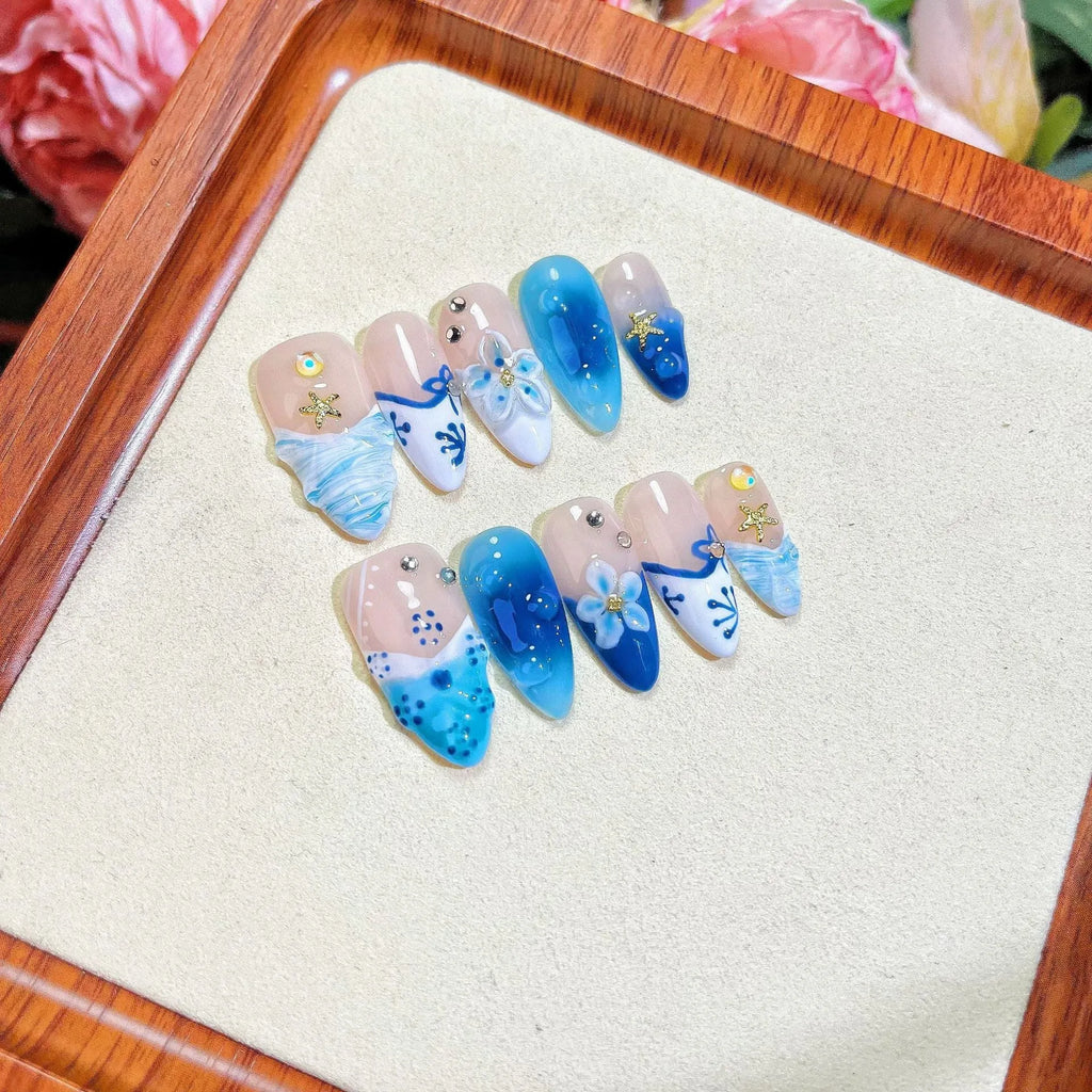 Blue hand-painted carved transparent fake nails set in sizes XS, S, M, L.