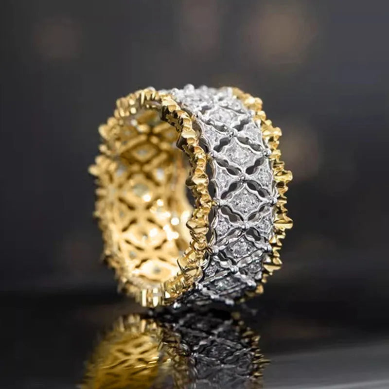 Geometric two-tone gold and silver zircon ring on a copper base, showing round stone detail.